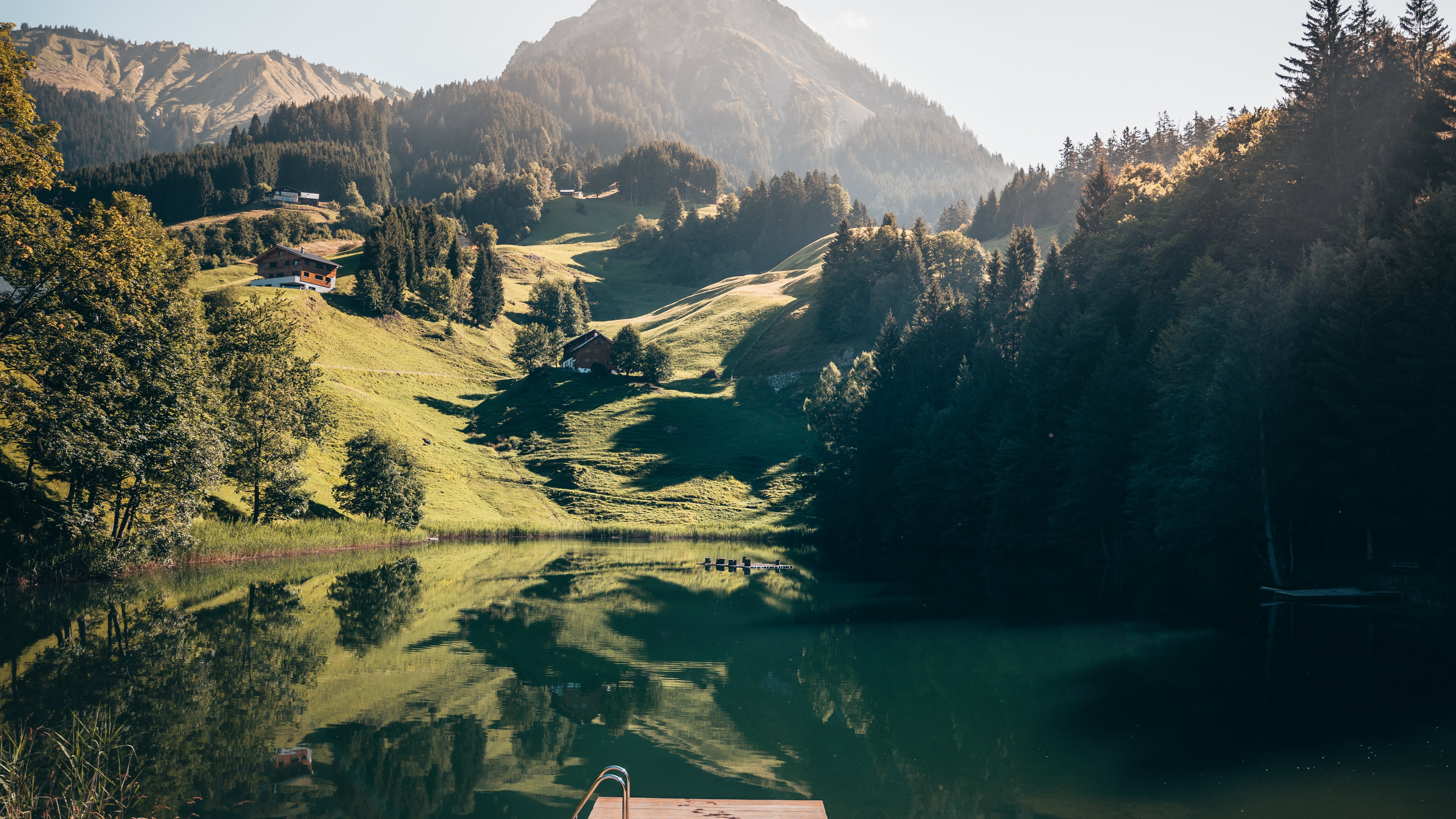 Beruhigende Berglandschaft mit einem See, umgeben von Hügeln und Bäumen, ideal für Naturfreunde.