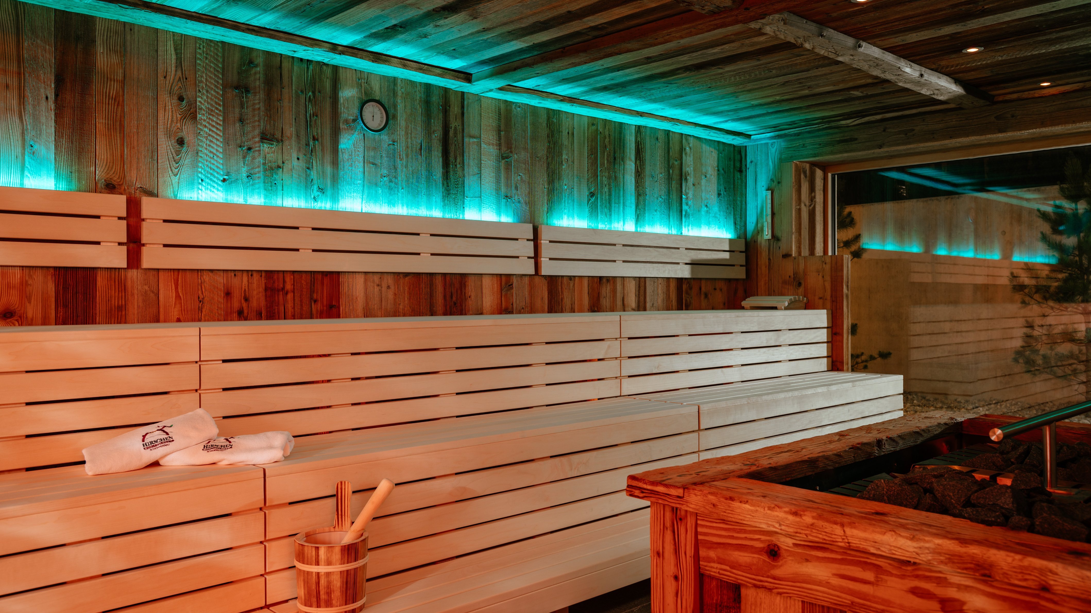 Eindrucksvolle Sauna-Oase im Hirschen Wohlfühlhotel Gemütliches Holzsaunainneres mit Bänken und sanfter Beleuchtung für Entspannung.