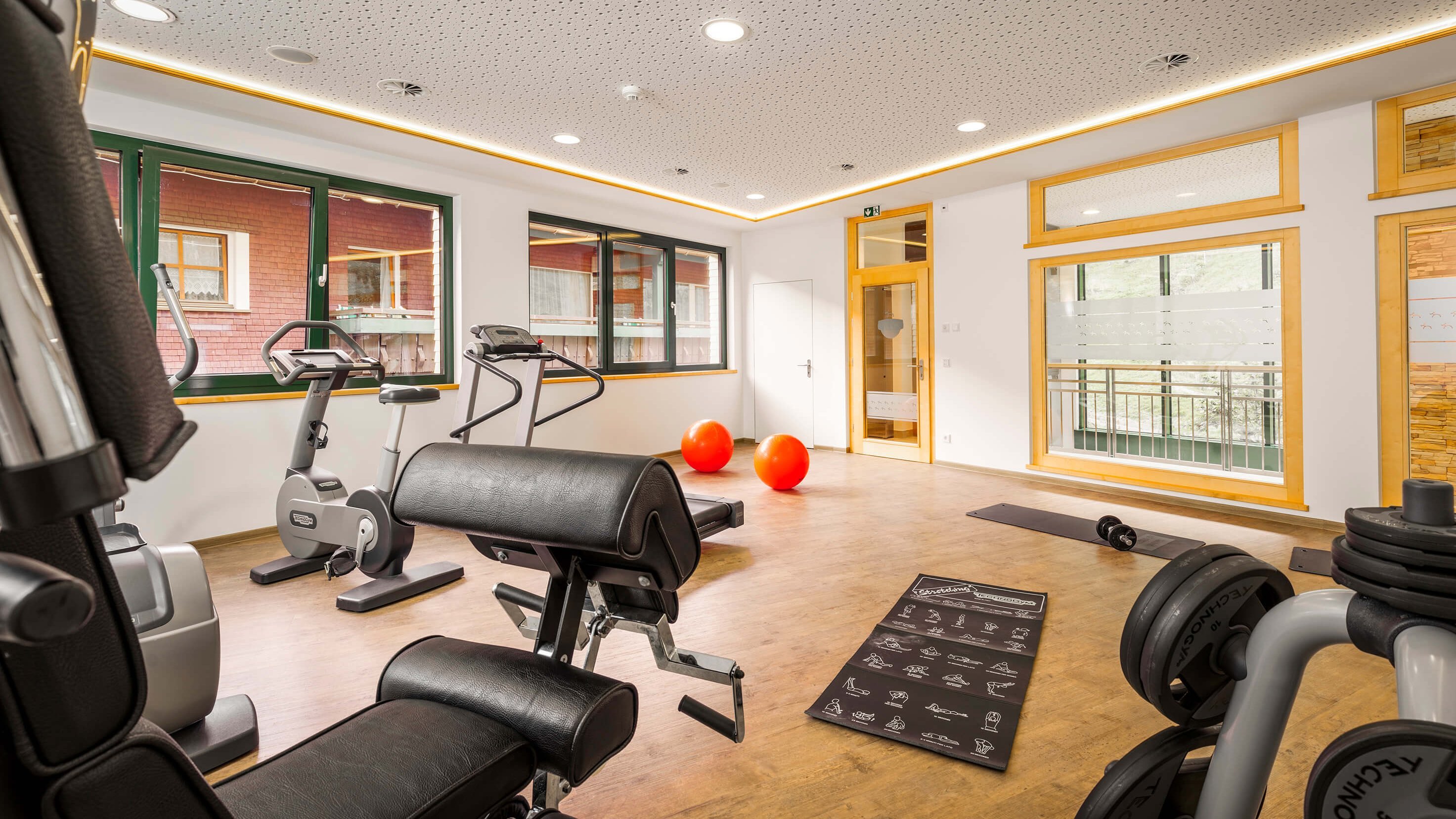 Relax and Recharge in Our Hotel Gym Modern hotel gym with exercise machines and weights for wellness activities in a bright space