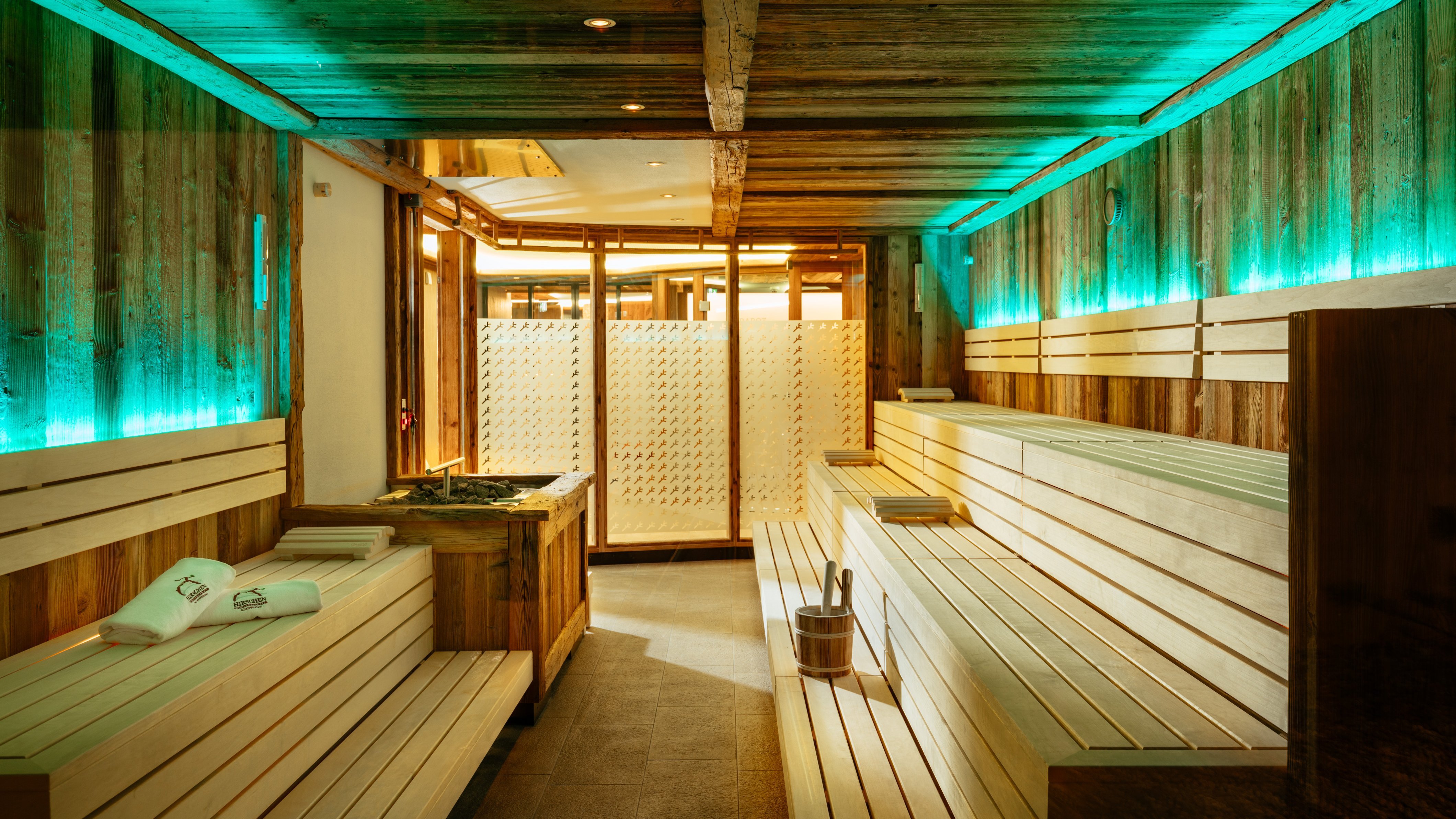 Sauna mit Holzbank und stimmungsvollem Licht für Wellness und Relaxation in einem Hotel.