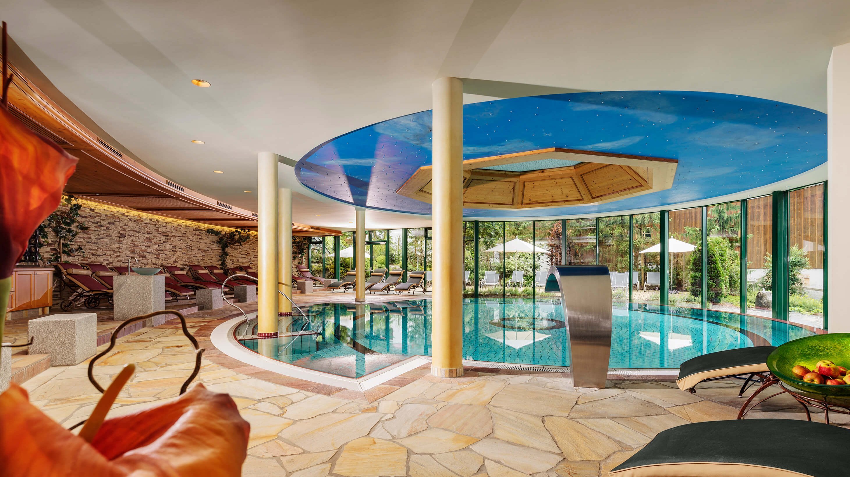 Indulge in Luxury at Hirschen Spa Indoor spa area featuring a serene pool and lounge chairs for relaxation and rejuvenation