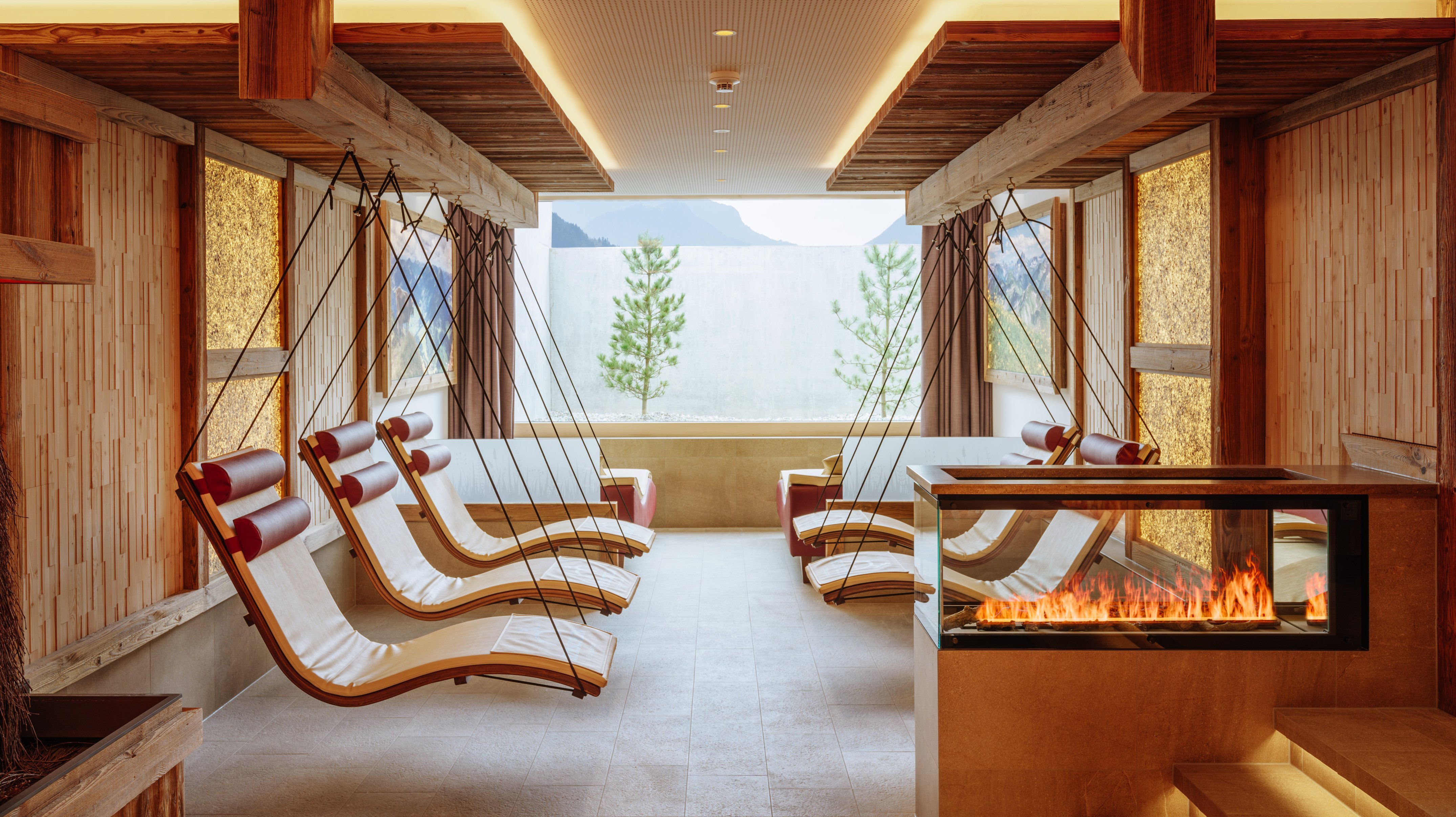 A calming relaxation area with lounge chairs and a cozy fireplace in a hotel spa